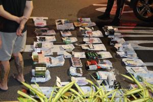 数名警员先后从车里取出多件包裹，拆剪后发现里头装有电子烟。（梁麒麟摄）