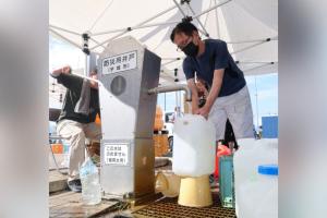 熊本地震发生至今已一周，许多灾民仍处于断水状态。图为8月5日，熊本县宇城市的民众前往一处防灾应急井取水。（法新社）