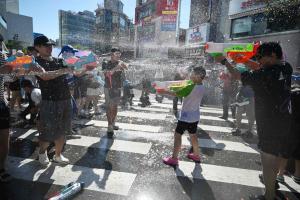 韩国今年立秋后依然继续经历高温天气，图为首尔星期六（8月8日）举办水枪节，供参与者玩乐解暑。（法新社）