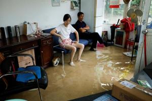 台风“白海豚”给上海带来暴雨后，星期一上海一户居民家中的积水已淹至脚踝。（路透社）