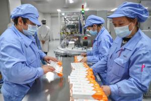 工作人员在中国北京科兴的冠病疫苗包装车间工作，图片摄于2021年1月6日。（新华社）