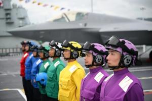 央视新闻星期六（8月15日）揭秘航母福建舰上的“彩虹编队”分工，指不同颜色马甲和头盔对应专属战位，形成中国独有的“航母彩虹服”体系。（央视新闻）