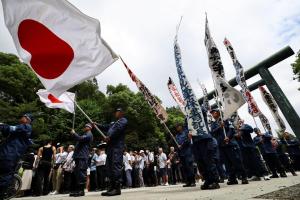 日本右翼人士星期六（8月15日）在靖国神社高举旗帜和标语。（路透社）