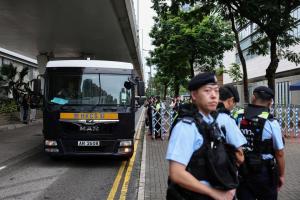香港法院星期五（8月21日）将对已解散的香港泛民主派组织支联会涉“煽动颠覆国家政权案”作出裁决。图为一辆囚车星期五上午抵达西九龙法院，警员在现场站岗维持秩序。（路透社）