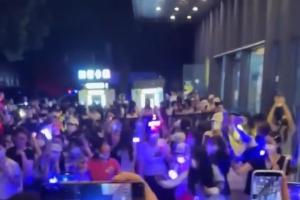 围绕时代峰峻的风波连日来持续发酵，图为一群人聚集在重庆长江国际大厦楼下，举起手机等候练习生进入公司。（互联网）