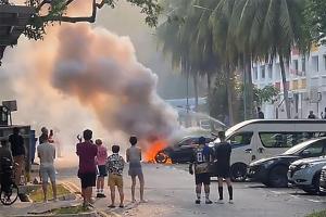 汽车起火，引擎舱遭烈火吞噬，不少公众站在远处围观。（TikTok视频截图）