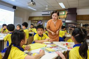 获颁2026年杰出华文教师奖的陈筠（中）在榜鹅小学任教14年。图为她在课堂上带领二年级学生进行桌游小组活动。（白艳琳摄）